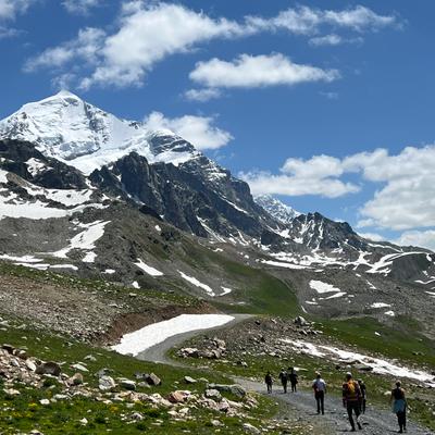 group of hikers on mountain path in Svaneti, Georgia on a clear sunny day.
