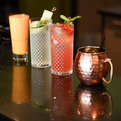 A selection of craft cocktails and a mixed drink served in varied glassware.