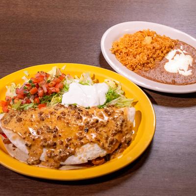 Quesadilla topped with meat sauce, served with fresh salsa, sour cream, rice, and beans.