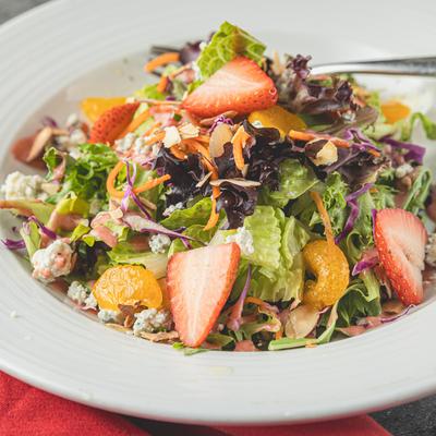 Salad with spinach, lettuce, strawberries, mandarins, blue cheese, almons, and vinaigrette.