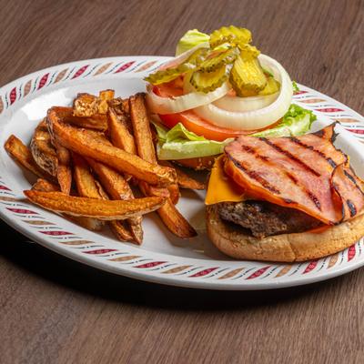 Burger with cheese and grilled ham served with sweet potato fries and fresh toppings.