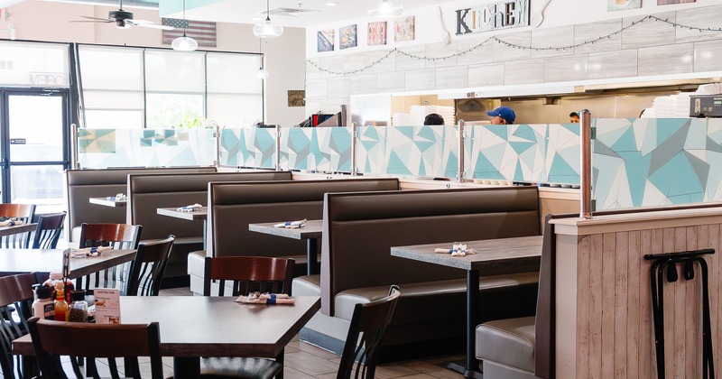 Cozy interior dining area with lined up dining booths, tables and chairs