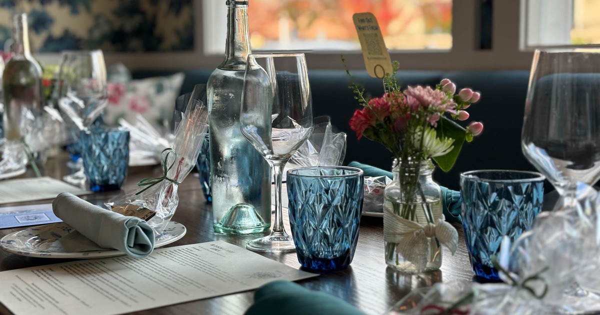 Plates, utensils, napkins, bottles, glasses and flower vases