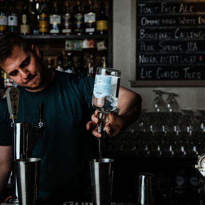 Bartender pouring drink into a shaker.