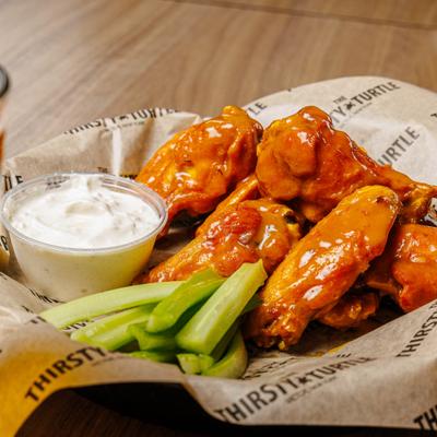 Wings served with celery sticks and a dipping sauce.
