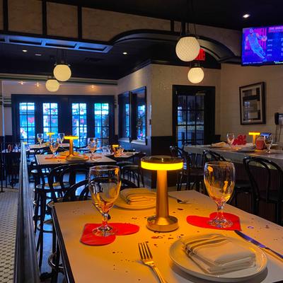 Interior with set tables, pendant lights, and a TV.