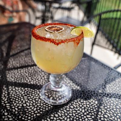 Margarita served in a chili-rimmed glass with a lime wedge garnish.
