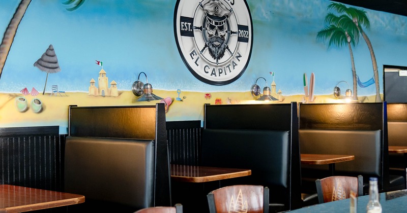 Interior, dining booths and mural on the wall with El Capitan logo