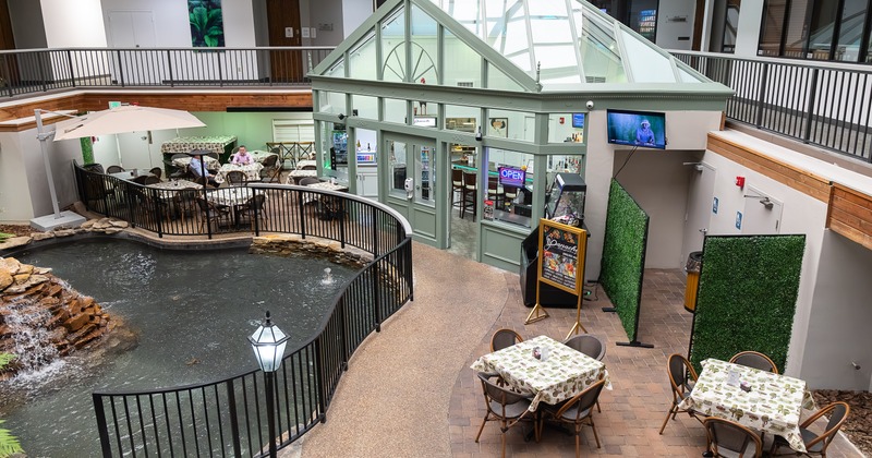 Spacious restaurant patio and dining area inside a bright indoor atrium office