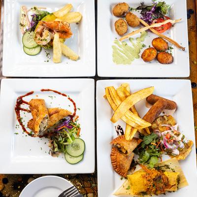 Four plates of assorted appetizers.