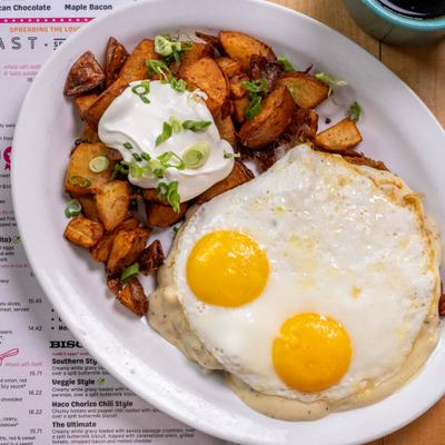 Two eggs, served with rustic potatoes and toast.