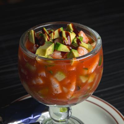 Shrimp cocktail with avocado in a goblet-style glass.