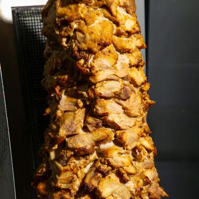 Meat cooking on a vertical rotisserie.