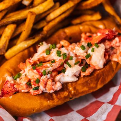 Close up of lobster roll with fries on the side.
