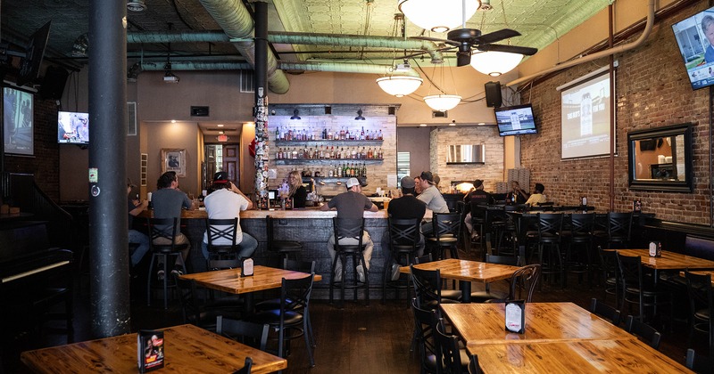 Interior, seating area and bar area, guest sitting at the bar