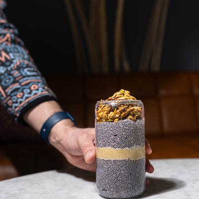 A hand holding a strawberry chia pudding.