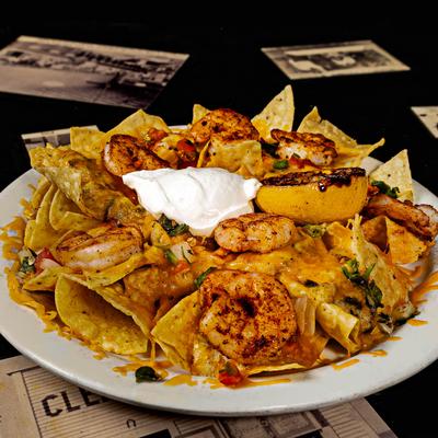 Shrimp nachos, with salsa, sour cream, and charred lemon.