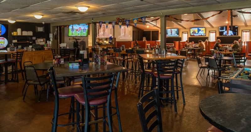 Interior, bar area, bar tables and chairs, diner area behind, tv screens, wide view
