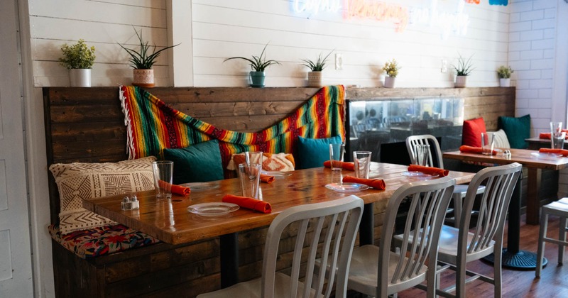 Interior, long banquette bench with tables and chairs, Mexican motif decoration