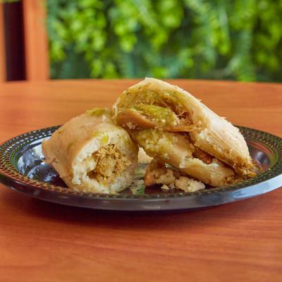 Steamed corn dough with jalapenos and cheese tamales on a table.