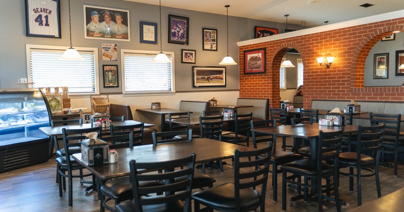 Interior with wooden tables, framed sports memorabilia on the walls and glass bakery display case