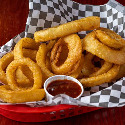 Onion rings served with a side of dipping sauce.
