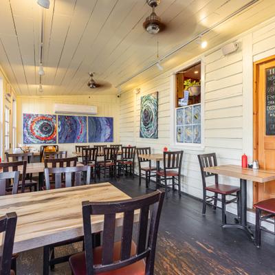 Interior with wooden tables and chairs and abstract art hang on the walls.