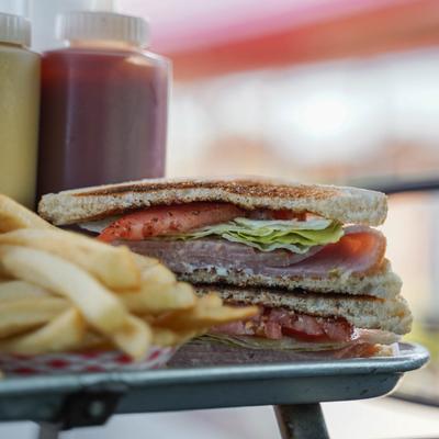 ham sandwich and french fries on a tray.