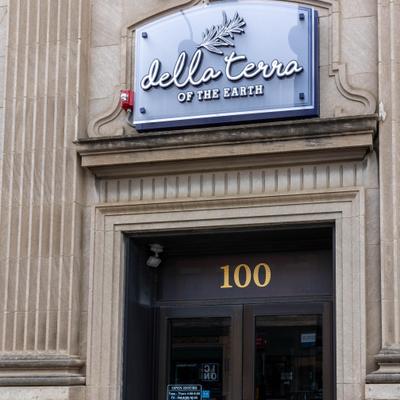 Elegant restaurant sign and entrance on textured stone exterior.