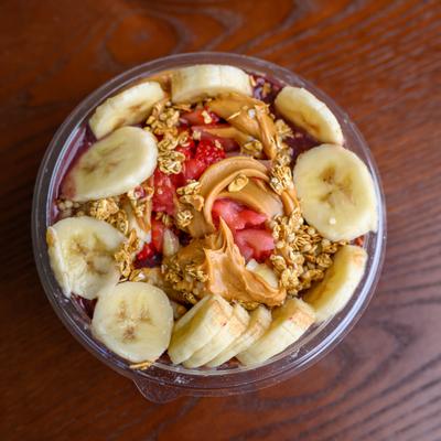 Gainz Bowl with peanut butter, sliced banana, strawberries and granola.