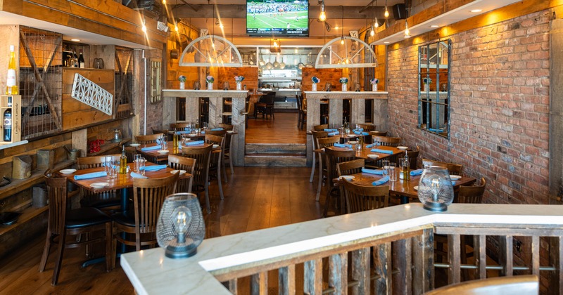 Interior, wooden tables, blue napkins, and a large television showing a sports game