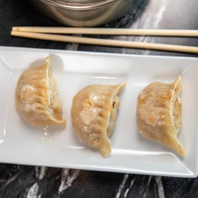 Three potstickers on a plate.
