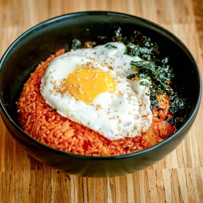Kimchi fried rice with fried egg on top and crushed, dry seaweed.