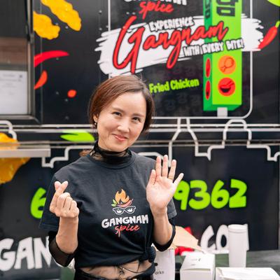 Chef Jiyeon, the founder of Gangnam Spice, posing in front of the food truck.