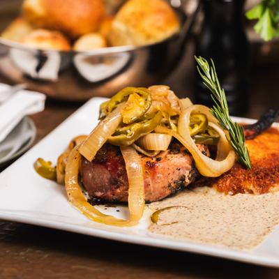 Pork Chop, Cheeses crusted potato pancake, cherry peppers and Guiness dijon sauce.