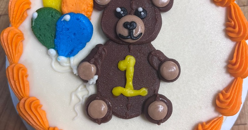Baby's one year smash cake.  Butter cream teddy bear and colorful balloons.