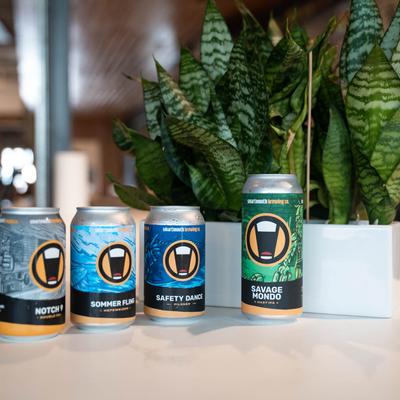 Smartmouth Brewing Co. canned beers lined up on a table.