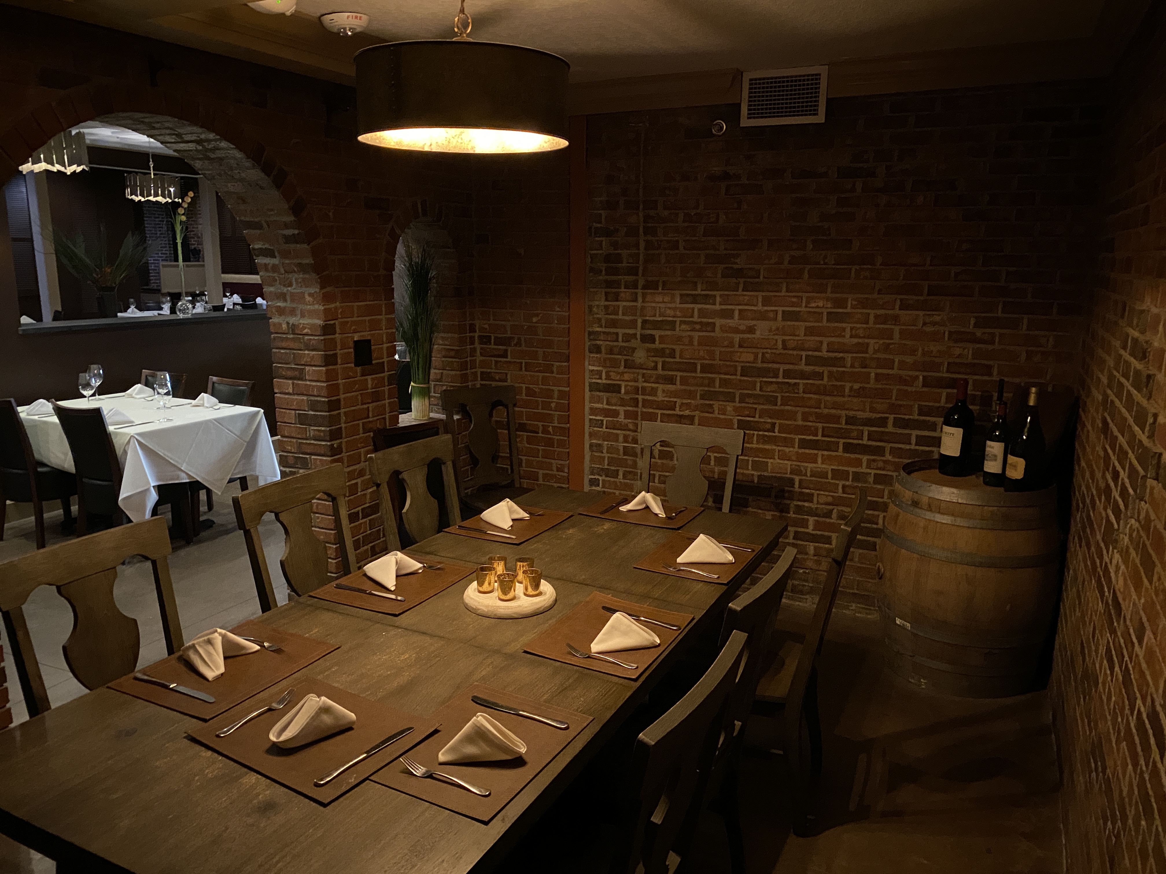 a wooden chefs table set for dining at a restaurant in a dimly lit bricked room