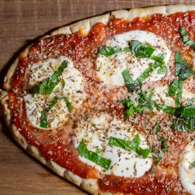 Margherita-style pizza topped with tomato sauce, fresh mozzarella, and basil.