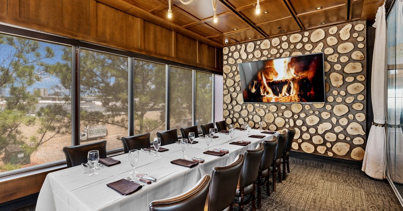 Interior, long set table by a wall with TV screen