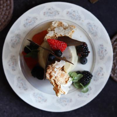 A top-down view of a panna cotta topped with berries.