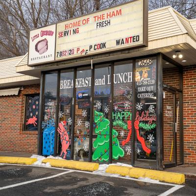 Entrance with signs and windows decorated for the holidays.