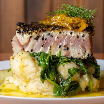 Sesame encrusted ahi tuna on a bed of sauteed greens and mashed potatoes.