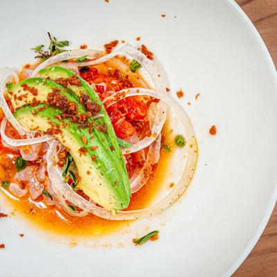 Carpaccio dish with thinly sliced meat and avocado slices
