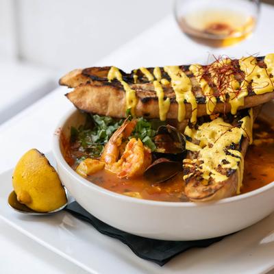 Seafood soup, with mussels, crab, shrimp, cod, fennel, tomato saffron broth, and crostini