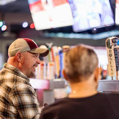 A person laughing while at a bar.