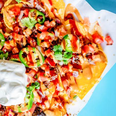 Brisket nachos topped with sour creme, close-up.