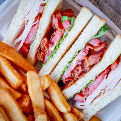 Close up of turkey club and fries.