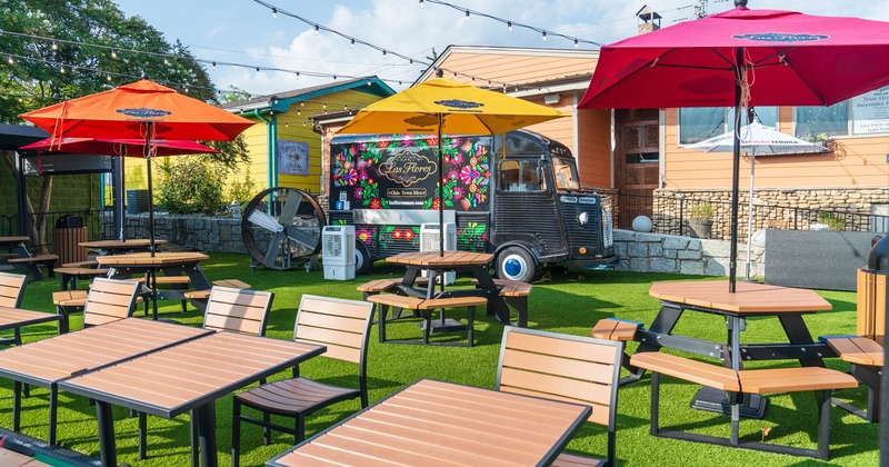 Las Flores food truck parked on grass patio with a seating area