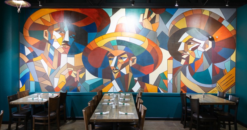 Interior, dining space with cubist looking art on the wall
